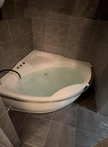 een badkuip in een betegelde badkamer bij B&M Mini jecuzzi Lovers room Self check-in in Vilnius