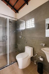 een badkamer met toilet, douche en wastafel bij Samarya Chikkamagaluru in Chikmagalūr +22 foto's