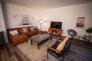 een woonkamer met een bank en een tv bij Luxury Coffee Bean Condo - Pool & Stunning View in Baie-Saint-Paul +41 foto's