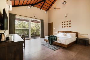 een slaapkamer met een bed en een groot raam bij Samarya Chikkamagaluru in Chikmagalūr