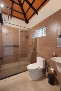een badkamer met een douche, een toilet en een wastafel bij Samarya Chikkamagaluru in Chikmagalūr