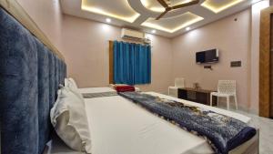 a large bed in a room with a tv at BRiJWAS DHAM in Vrindāvan