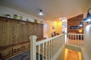 een hal met een trap met houten lambrisering en een bakstenen muur bij Tee Time and Lake Fun at Tagalong in Birchwood