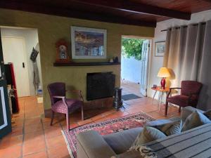 a living room with a couch and a fireplace at Maggie Rose Cottage Self Catering in Greyton in Greyton
