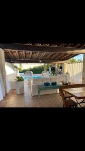 een patio met een tafel en een tafel en stoelen bij Villa Nazarena in Torre Suda