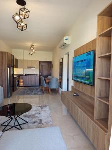 een woonkamer met een flatscreen-tv aan de muur bij Golf Heights Resort Nabk Bay Sharm El Sheikh One Bedroom Apartment in Sharm El Sheikh