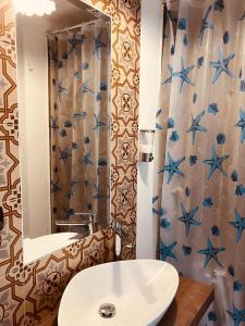 een badkamer met een witte wastafel en een spiegel bij Villa Nazarena in Torre Suda