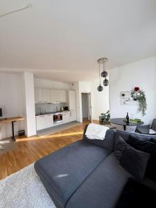 een woonkamer met een blauwe bank en een keuken bij Apartment und Ferienwohnung Scharnhorststraße, Berlin-Mitte in Oranienburg