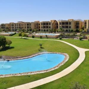 een resort met een zwembad en een gebouw bij Golf Heights Resort Nabk Bay Sharm El Sheikh One Bedroom Apartment in Sharm El Sheikh