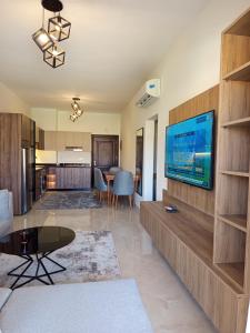 een woonkamer met een grote flatscreen-tv aan de muur bij Golf Heights Resort Nabk Bay Sharm El Sheikh One Bedroom Apartment in Sharm El Sheikh