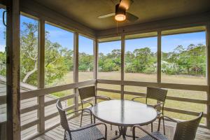 a screened porch with a table and chairs at Creekwatch 1245 in Seabrook Island