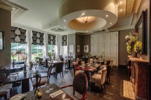 a restaurant with tables and chairs and a large ceiling at Bannatyne Hotel Darlington in Darlington