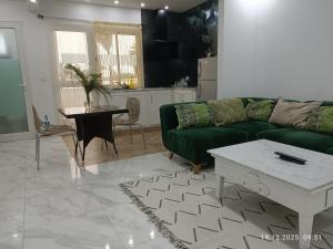 a living room with a green couch and a table at Résidence Debbabi in Monastir +5 photos