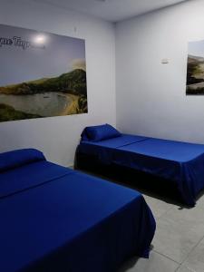 two beds in a room with a painting on the wall at Apartamentos Erica 303 en el Centro histórico de Santa Marta in Santa Marta +7 photos