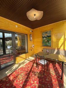 een eetkamer met een tafel en een tapijt bij Ala-Tor Guest House in Pokrovka