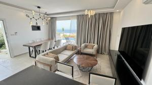a living room with a couch and a dining room at Sunset Poseidon by Carrington in Kyrenia