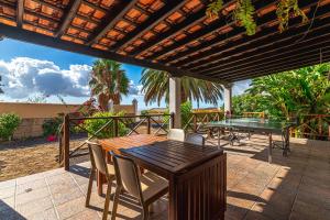 un patio con tavolo e sedie su un ponte di Villa Aurora with Heated Pool a La Cisnera