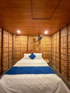 ein Schlafzimmer mit einem Bett in einer Holzwand in der Unterkunft Vihara Inn Resort in Vayittiri