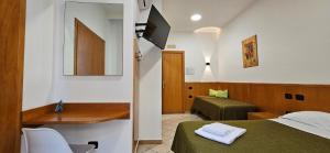 a room with a bed and a desk and a television at Hotel Zara Napoli in Naples
