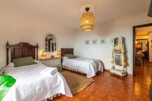 una camera da letto con due letti e uno specchio di Villa Aurora with Heated Pool a La Cisnera Altre 18 foto