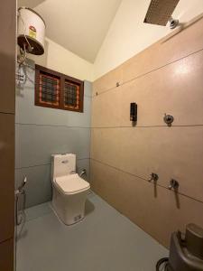 ein Badezimmer mit Toilette und Fenster in der Unterkunft Vihara Inn Resort in Vayittiri