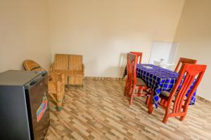 卡塞斯Kasese Airstrip Homestay的一间有桌椅和电视的餐厅