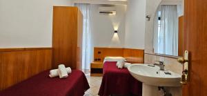 a bathroom with a sink and a bed and a sink at Hotel Zara Napoli in Naples