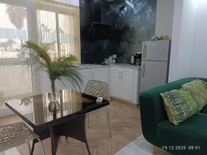 a living room with a table and a green couch at Résidence Debbabi in Monastir