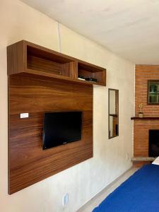 a flat screen tv mounted on a wall at Casa Moreira´s Chalés in Monte Verde