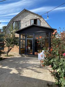 een gebouw met een grote glazen deur met bloemen bij Ala-Tor Guest House in Pokrovka
