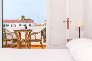 a bedroom with a balcony with a table and chairs at Villa Jultomas in Cala en Bosc +19 photos
