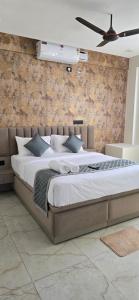 a bedroom with a large bed with a ceiling at Hotel Airport Transit in Bengaluru