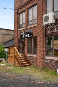 a brick building with stairs and a sign on it at Bridge View at The MillRows Suites in New Glasgow