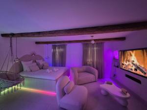 ein lila Wohnzimmer mit Sofa und Fernseher in der Unterkunft Kama Muta in Callas