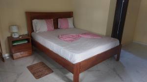 ein Bett mit einem rosa Morgenmantel darauf in der Unterkunft Ké San Gélica in São Tomé