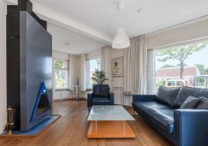 ein Wohnzimmer mit einer schwarzen Couch und einem Fernseher in der Unterkunft Vakantiewoning Afterdaan in Elim