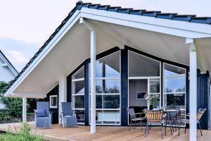 德雷施维茨Lille Traehus的木制甲板上配有桌椅的凉亭