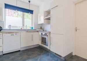 eine Küche mit weißen Schränken und einem Fenster in der Unterkunft Vakantiewoning Afterdaan in Elim