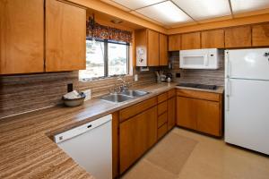 una cucina con mobili in legno e un frigorifero bianco di Ocean Treasures a Smith River