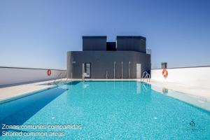 a swimming pool in front of a building at Living4malaga Tower Horizon in Málaga