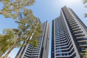 two tall buildings with trees in the foreground at Living4malaga Tower Horizon in Málaga