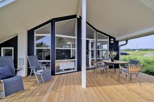 a covered deck with a table and chairs at Lille Traehus in Dreschvitz