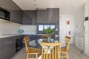 a kitchen with a glass table and chairs in a kitchen at Living4malaga Tower Horizon in Málaga