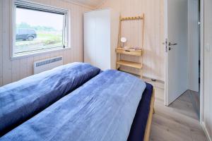 a bedroom with a large bed and a window at Lille Traehus in Dreschvitz