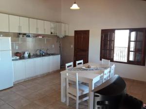 a kitchen with a white table and chairs in a room at Departamento ALEM in Federación