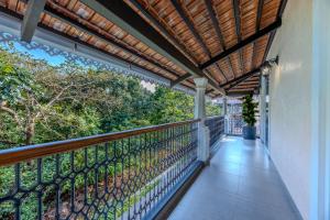 a balcony with a wooden roof and a fence at ELIVAAS Signature Cygnus with Pvt pool in Mapusa