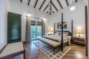 a bedroom with a bed and a large window at ELIVAAS Signature Cygnus with Pvt pool in Mapusa