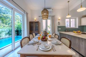 a kitchen and dining room with a table and chairs at ELIVAAS Signature Cygnus with Pvt pool in Mapusa