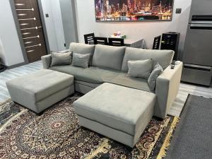 ein Wohnzimmer mit einem grauen Sofa und Ottomane in der Unterkunft Barkat Manzil in Bharūch + 9 Fotos