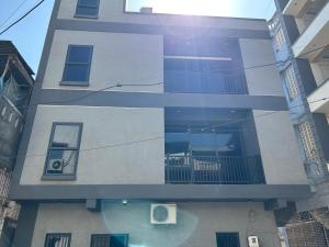 ein hohes Gebäude mit einem Fenster und einem Balkon in der Unterkunft Barkat Manzil in Bharūch